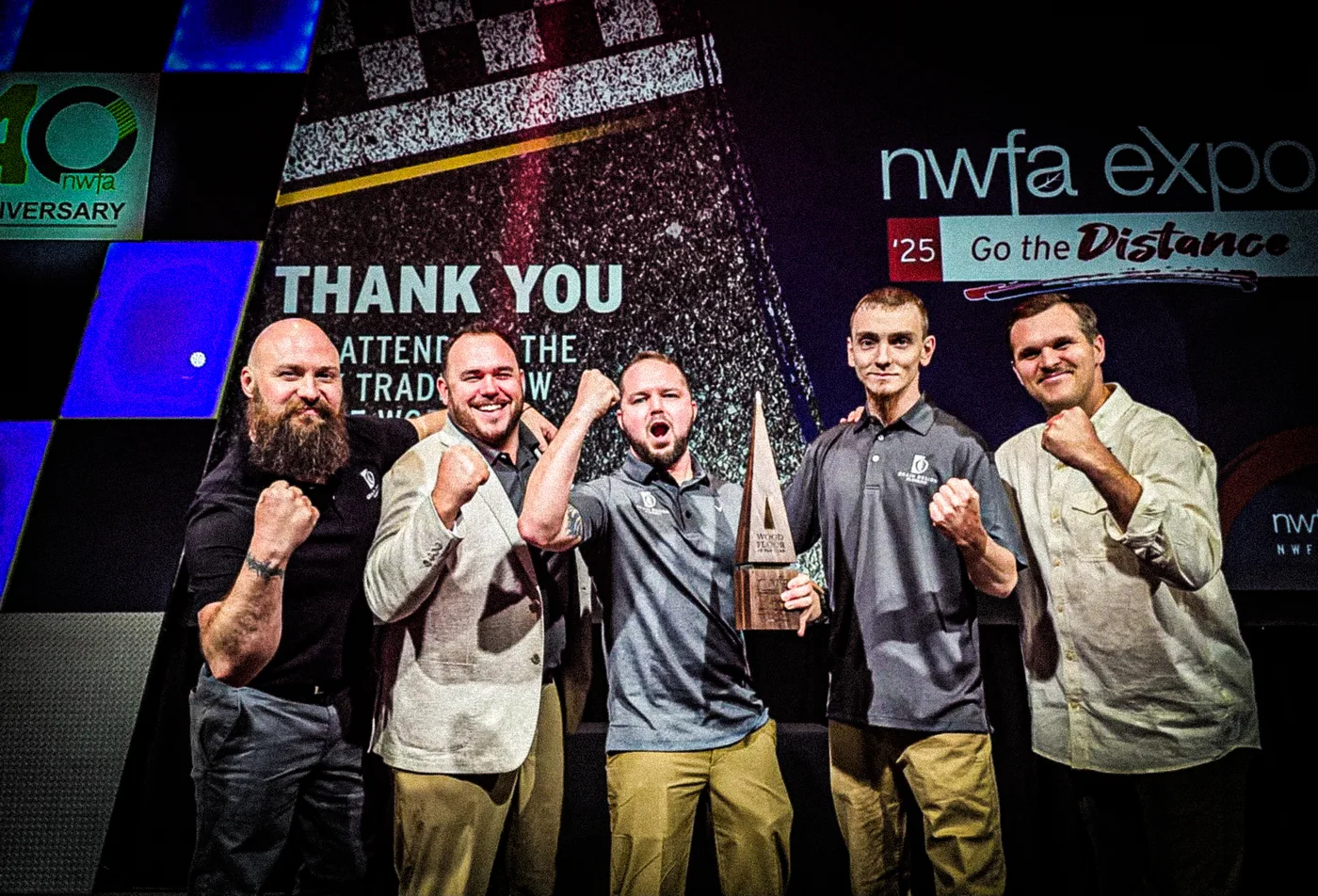 The Grain Design Flooring crew accepting the 2025 NWFA Wood Floor of the Year award at the NWFA Expo