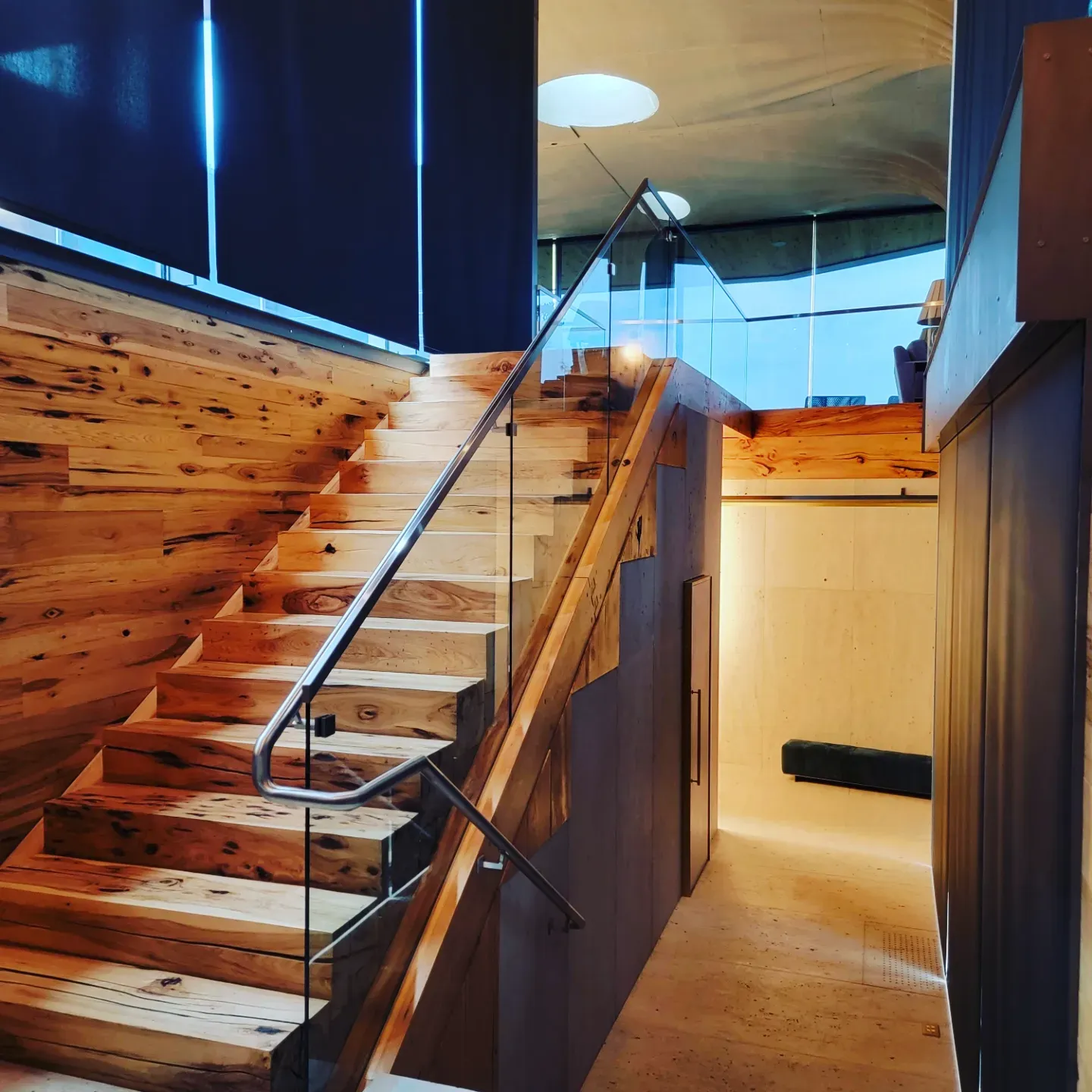 Floating reclaimed-wood staircase with a glass rail