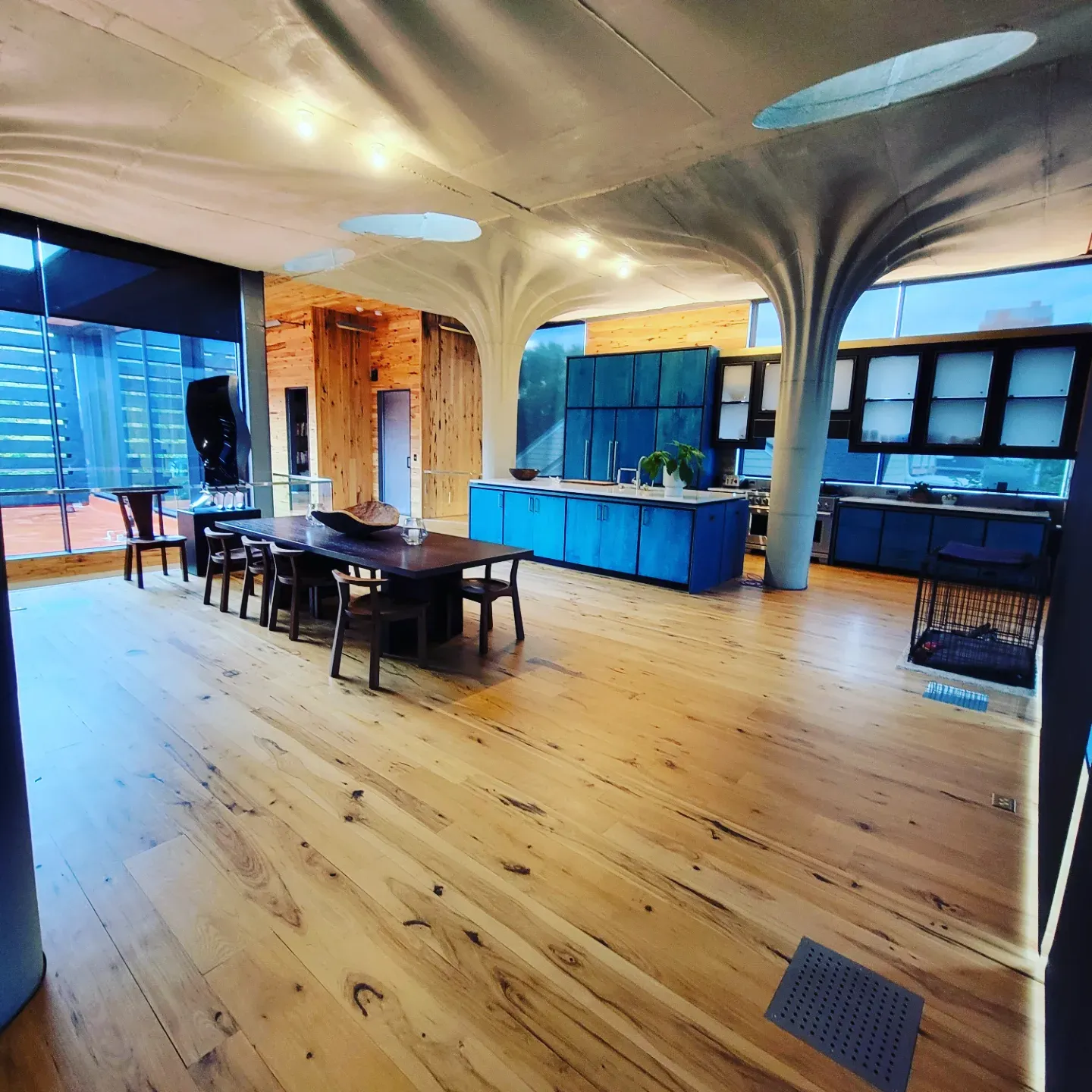 Wide-plank hardwood floor in an open space with sculptural concrete columns